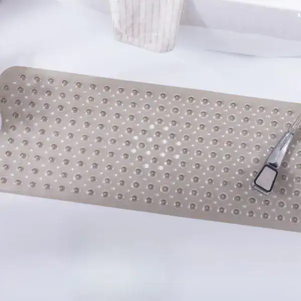 Badematte mit rutschfesten Punkten und Duschbrause im Bad.