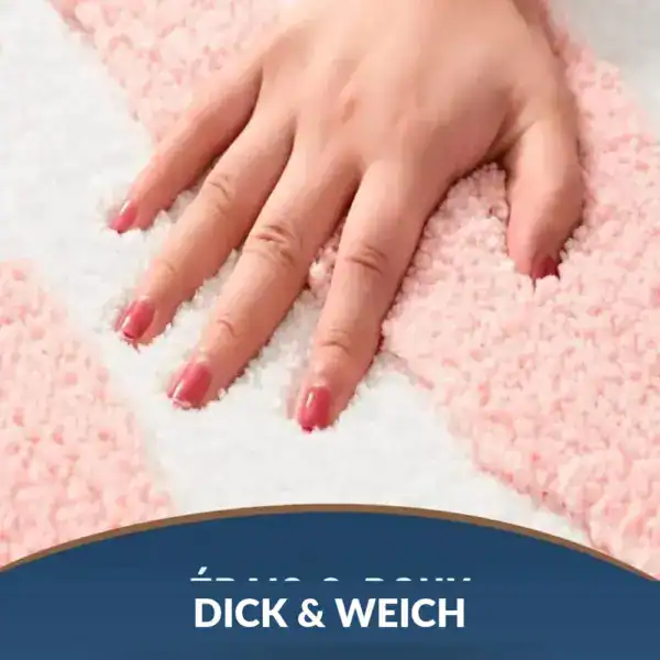 Altrosa Badematte mit weichem, flauschigem Oberflächenmuster und Hand darauf.