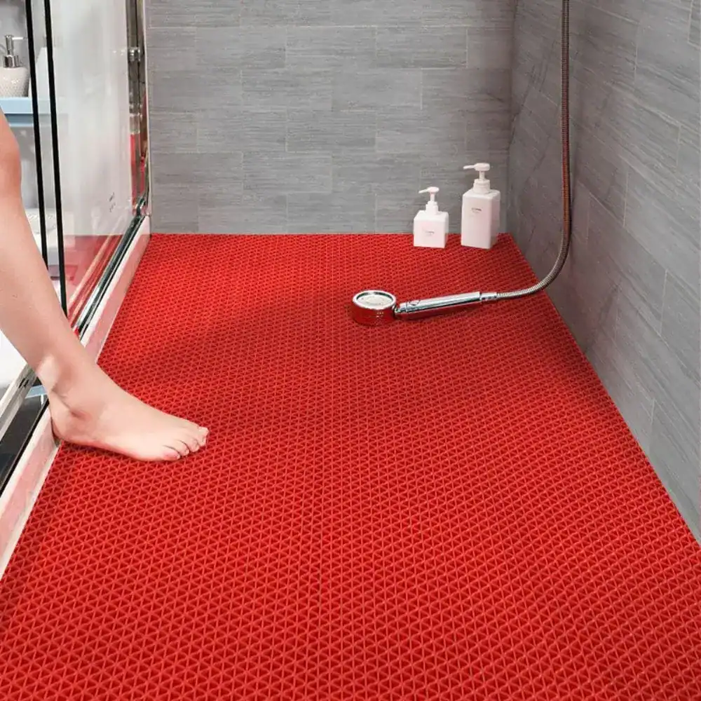 Rote Badematte Dusche mit rutschfestem Muster, Fuß darauf stehend.