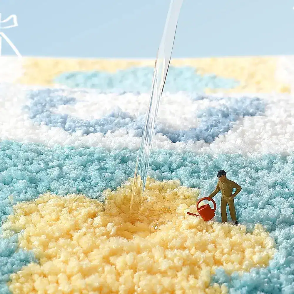 Floral Badematte mit blau-weiß-gelbem Muster, Wasser tropft auf weiches Material.