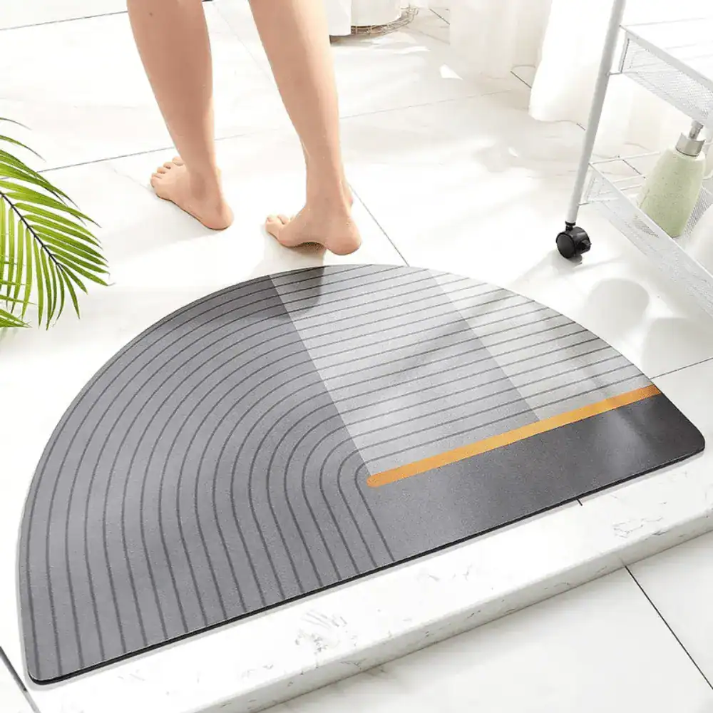 Gestreifte Badematte mit halbrundem Design und orangefarbenem Akzentstreifen für moderne Badezimmer.