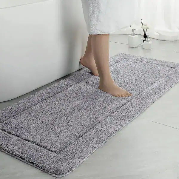 Große graue Badematte mit weichem Flor, ideal für komfortables Stehen nach dem Baden.