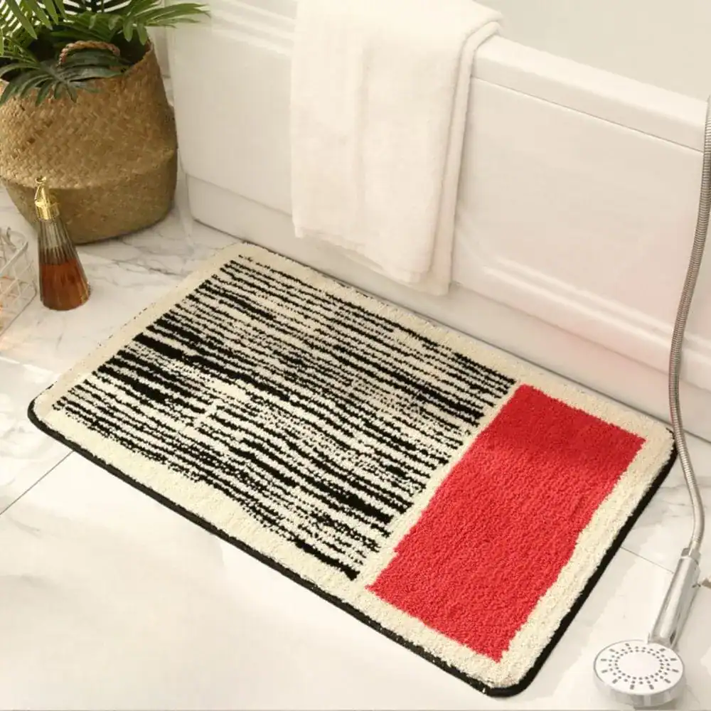Modernes Badematte-Design mit schwarz-weißem Streifenmuster und rotem Akzentfeld für stilvolle Badezimmer.