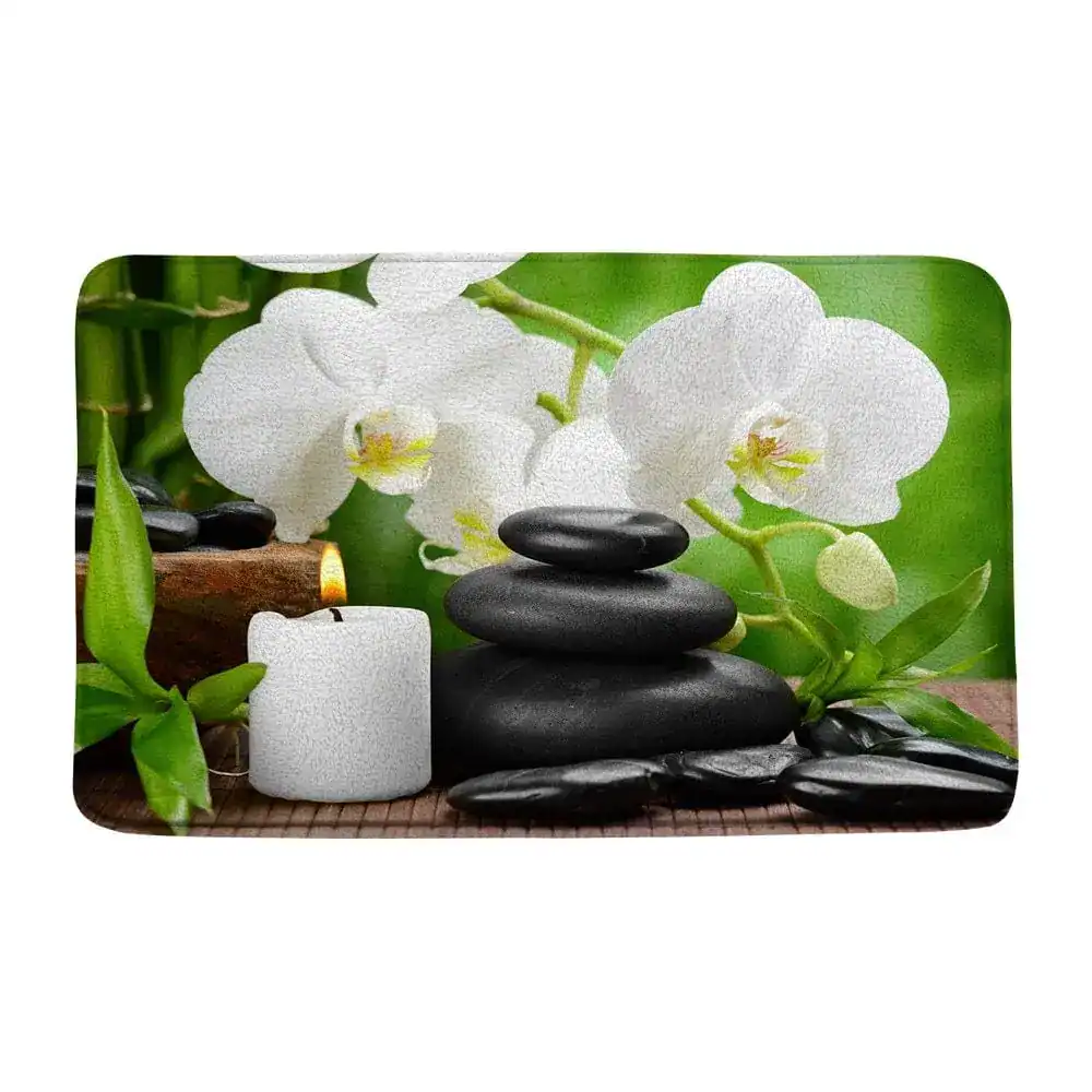 Wellness-Badematte mit Orchidee, Steine und Kerze für entspanntes Badezimmer.
