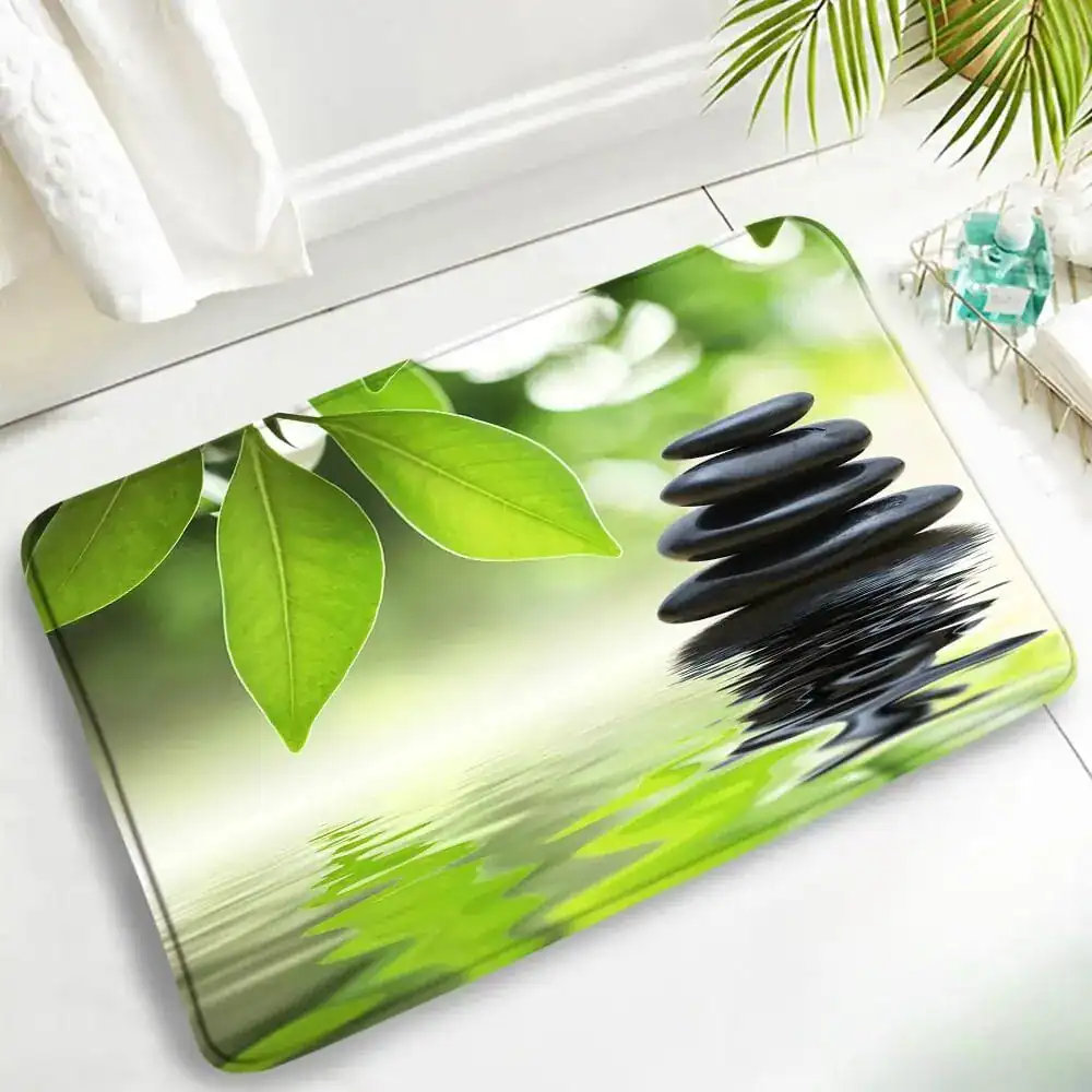 Zen-Badematte mit grünen Blättern und Steinpyramide, entspanntes Design für Badezimmer.