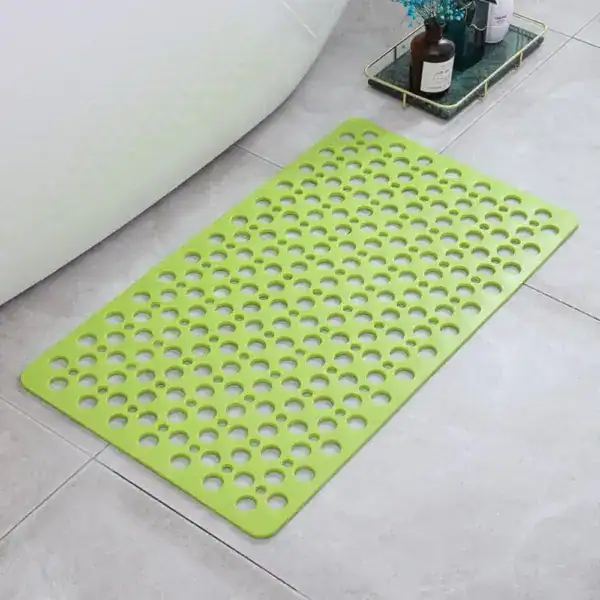 Grüner Duschvorleger mit perforierter Oberfläche für sicheren Stand im Badezimmer.