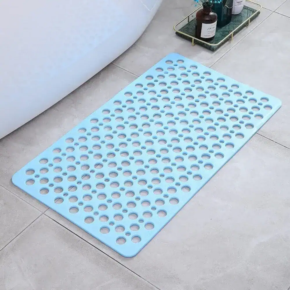 Blauer Duschvorleger mit runden Löchern für bessere Drainage im Badezimmer.