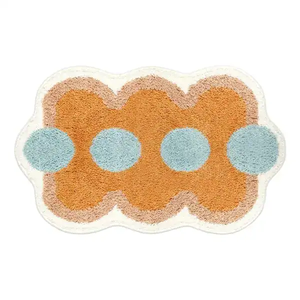 Orange Badezimmermatte mit blauen Punkten und welligem Rand.