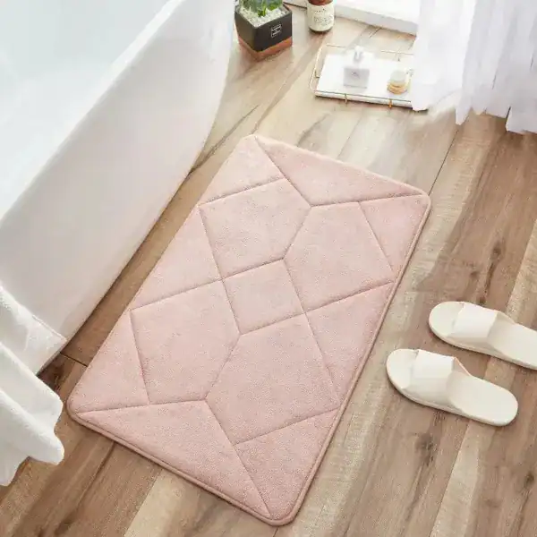 Antirutsch Badezimmerteppich rosa mit geometrischem Muster vor Badewanne.