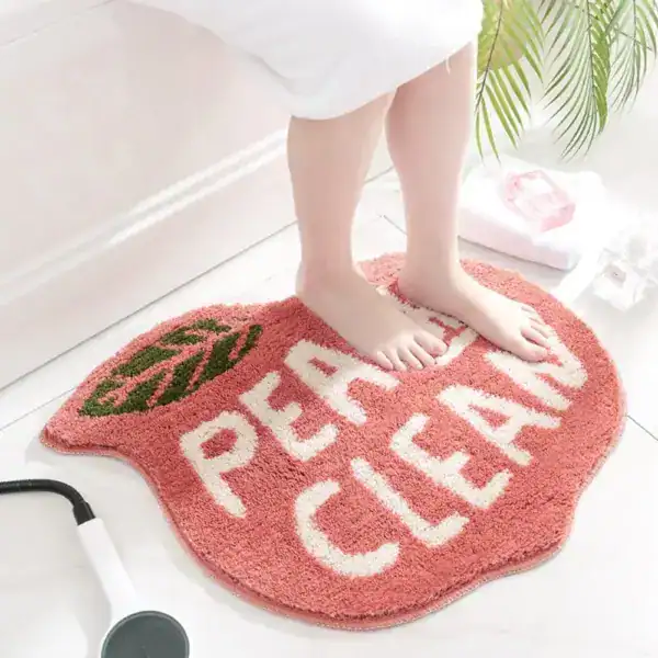 Apricot-farbener Badezimmerteppich mit 'PERFECT CLEAN' Aufschrift und Blattmotiv.