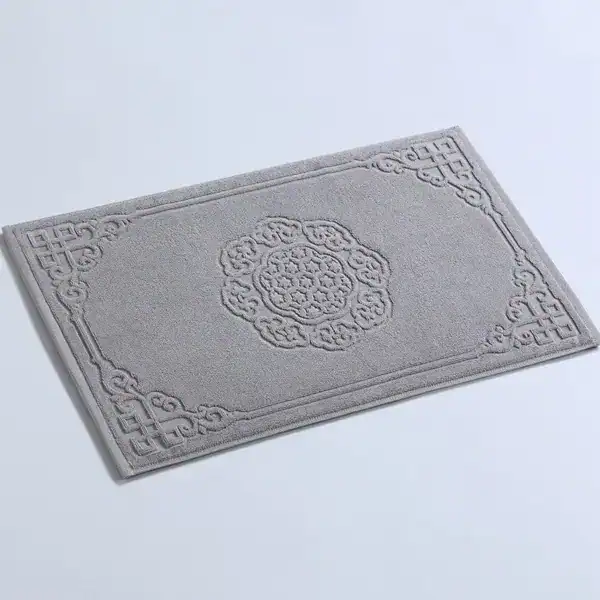 Großer Badezimmerteppich aus Baumwolle mit filigranem Muster und dekorativem Rand.