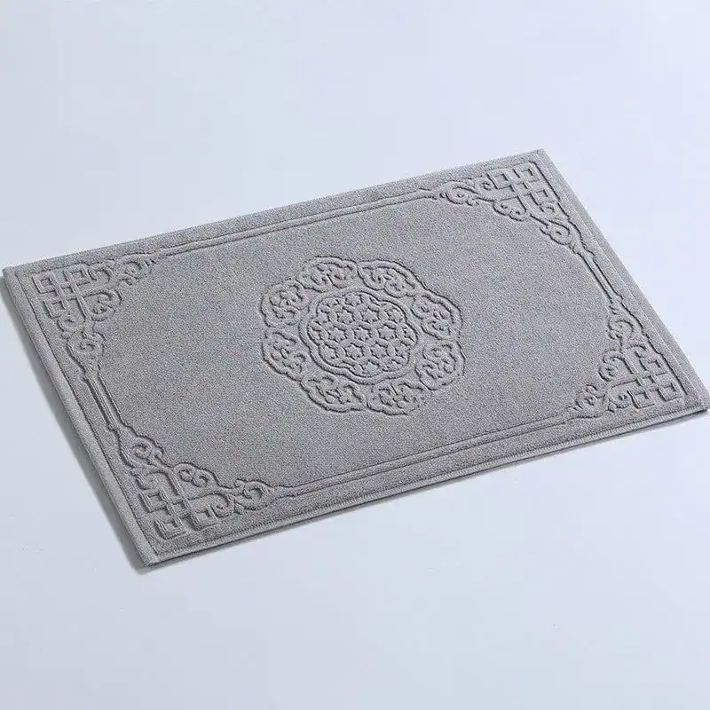 Großer Badezimmerteppich aus Baumwolle mit filigranem Muster und dekorativem Rand.