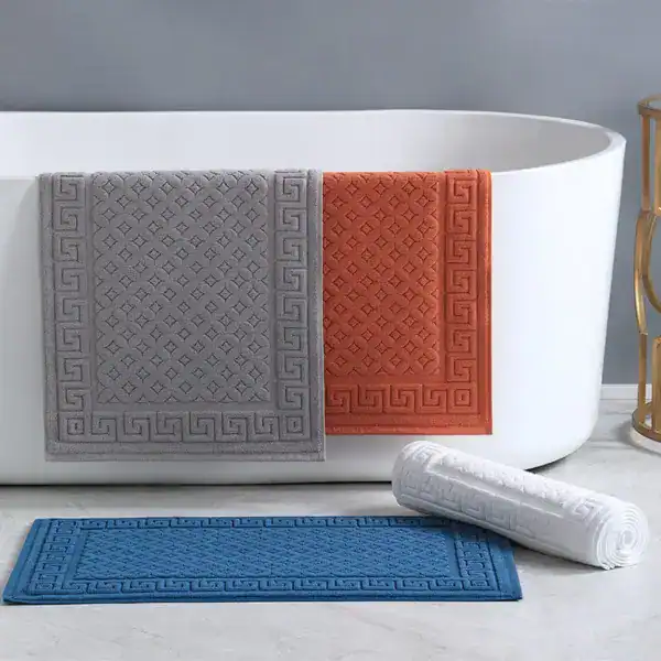 Rutschfester Badezimmerteppich aus Baumwolle mit griechischem Muster in Grau, Orange und Blau.