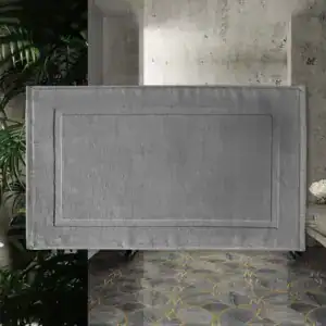 Silbergrauer Badezimmerteppich aus Baumwolle mit gerippter Bordüre und modernem Design.