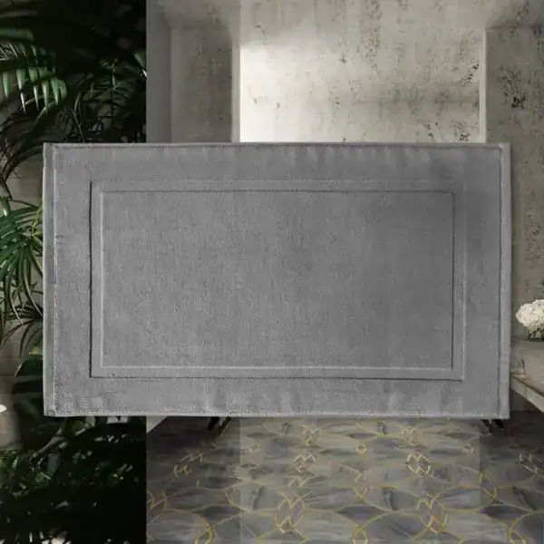 Silbergrauer Badezimmerteppich aus Baumwolle mit gerippter Bordüre und modernem Design.