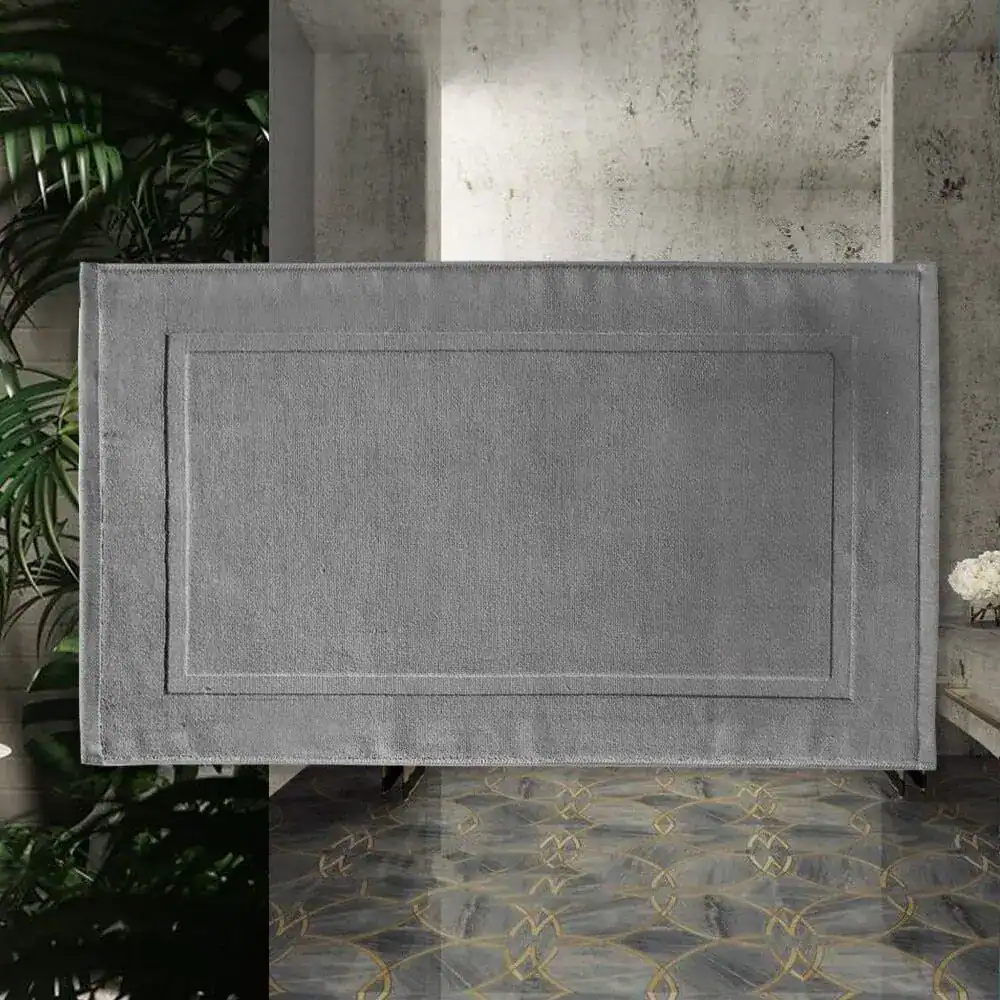 Silbergrauer Badezimmerteppich aus Baumwolle mit gerippter Bordüre und modernem Design.