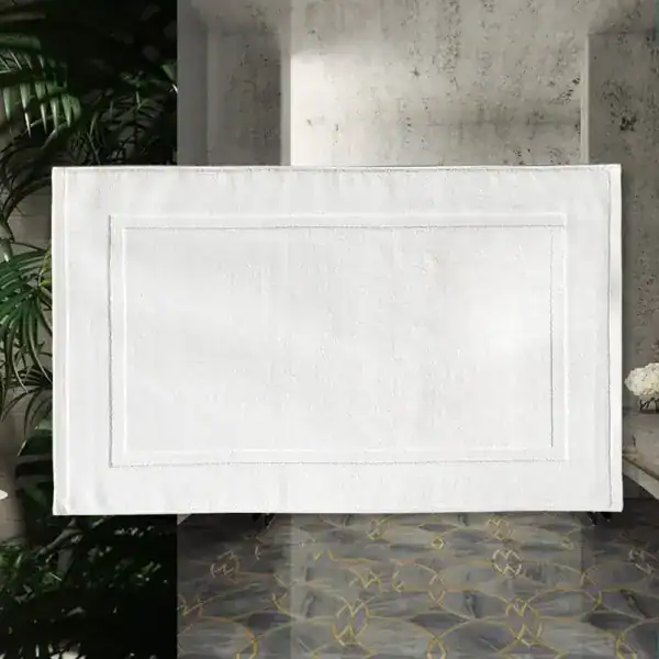 Weißer Badezimmerteppich aus Baumwolle mit Bordüre, ideal für Bad und Dusche.