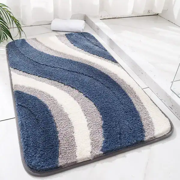 Blauer und grauer Badezimmerteppich mit wellenförmigem Muster und weicher Textur.