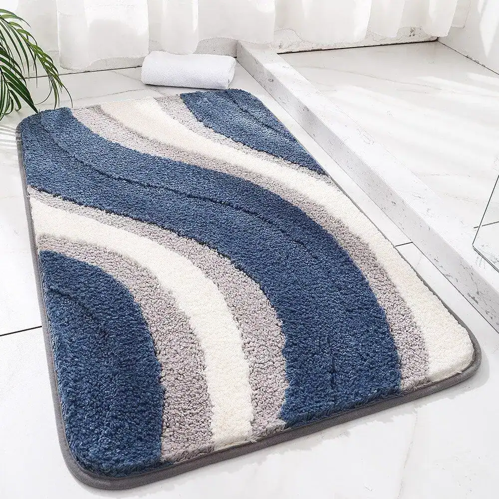 Blauer und grauer Badezimmerteppich mit wellenförmigem Muster und weicher Textur.