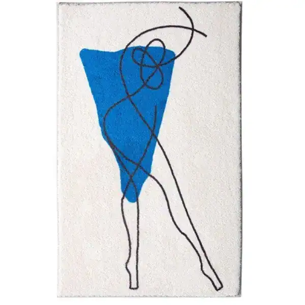 Grafisch gestalteter Badezimmerteppich mit blauem Dreieck und schwarzen Linien auf cremefarbenem Grund.
