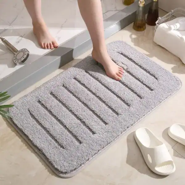 Grauer Badezimmerteppich mit Drainage-Strukturen für optimale Feuchtigkeitsableitung.