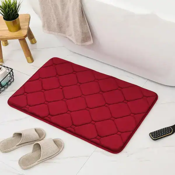 Rot gefärbter Memory Foam Badezimmerteppich mit Quilt-Design vor Badewanne.