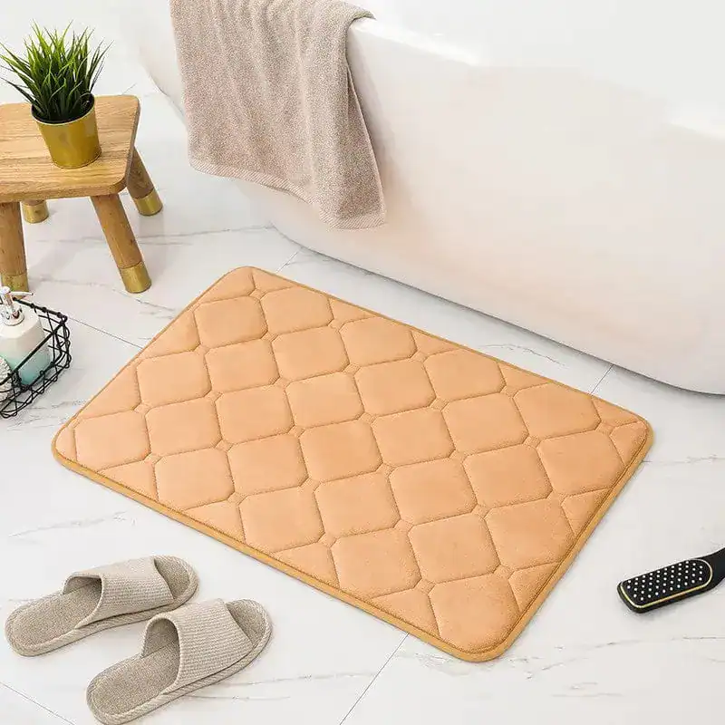 Beige Memory Foam Badezimmerteppich mit Quilt-Optik vor Badewanne.