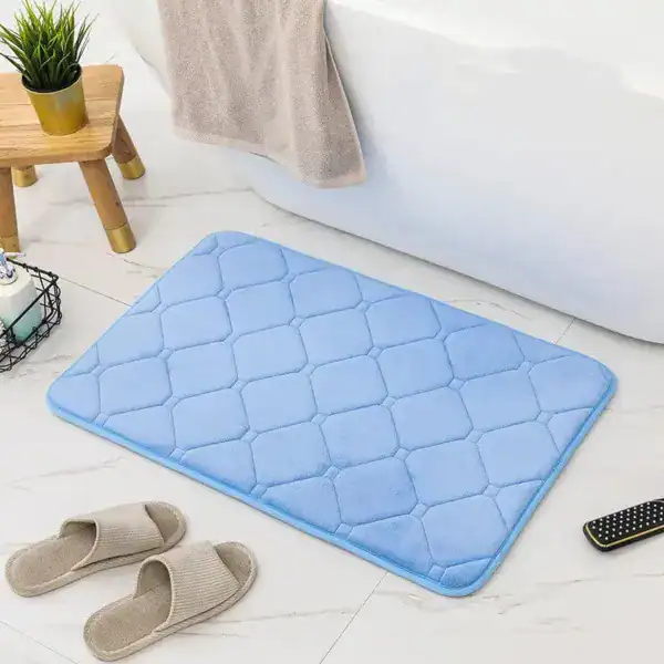 Blauer Memory-Foam-Badezimmerteppich mit Quilt-Struktur vor Badewanne.