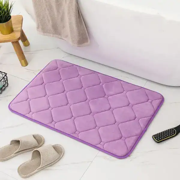 Lila Memory Foam Badezimmerteppich mit Quilt-Struktur vor Badewanne.