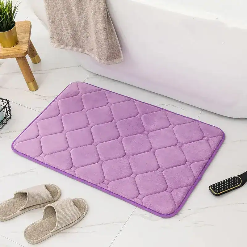 Lila Memory Foam Badezimmerteppich mit Quilt-Struktur vor Badewanne.