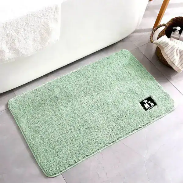 Mintgrüner Badezimmerteppich mit weicher Oberfläche vor Badewanne.