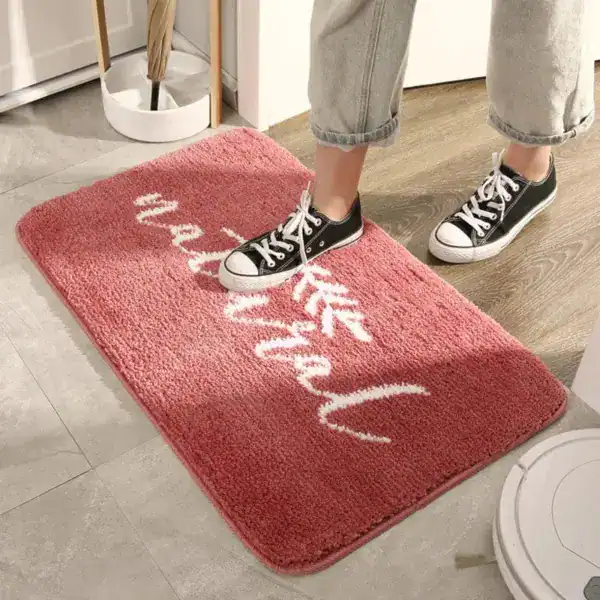 Natur-Badezimmerteppich rosa mit weißem Schriftzug, weicher Faser für Komfort und Stil.