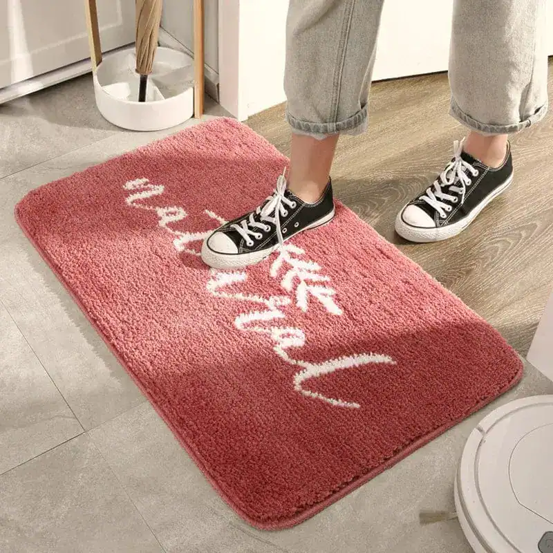 Natur-Badezimmerteppich rosa mit weißem Schriftzug, weicher Faser für Komfort und Stil.