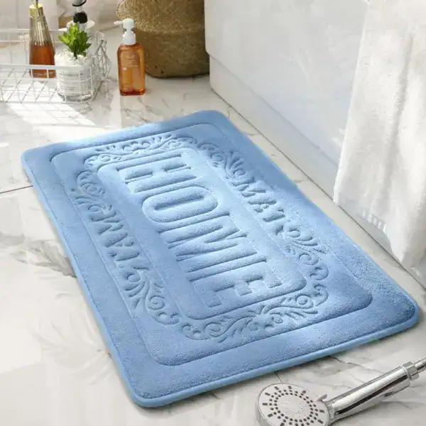 Blauer rechteckiger Badezimmerteppich mit Muster und Text 'HOME' auf Marmor-Boden.