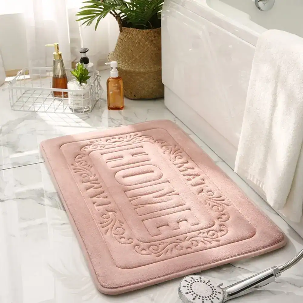 Pinkfarbener Badezimmerteppich mit 'HOME'-Aufdruck, rechteckig, für Bad und Dusche.