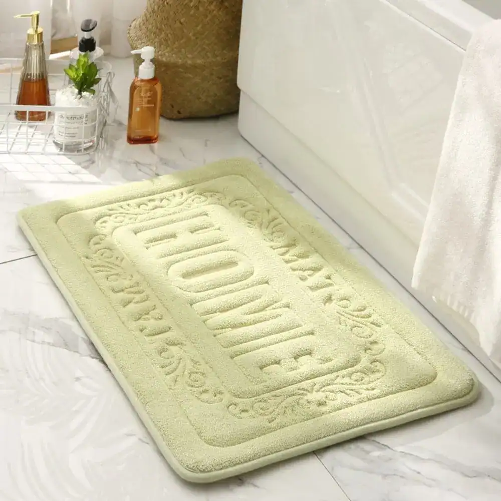 Rechteckiger Badezimmerteppich in Mintgrün mit 'HOME'-Schriftzug und floraler Bordüre.