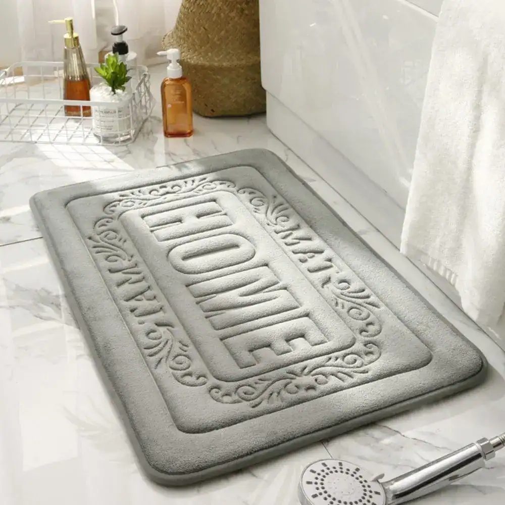 Rechteckiger Badezimmerteppich mit 'HOME'-Aufdruck, grau, für Bad und Dusche.