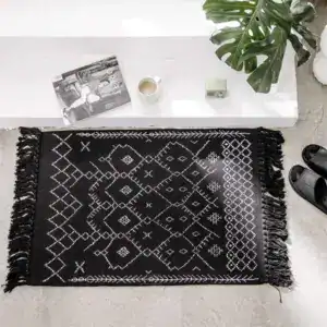 Schwarzer Badezimmerteppich aus Baumwolle mit geometrischem Muster und Fransen.