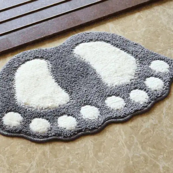 Ausgefallener Badteppich in Fußform mit grau-weißem Design für moderne Badezimmer.