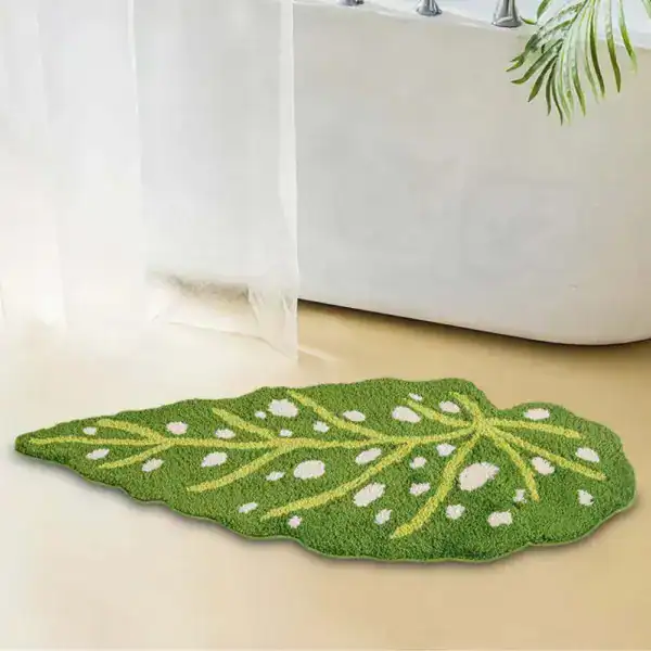 Grüner Badteppich in Blattform mit weißen Punkten und gelben Adern, ideal für Badezimmer.