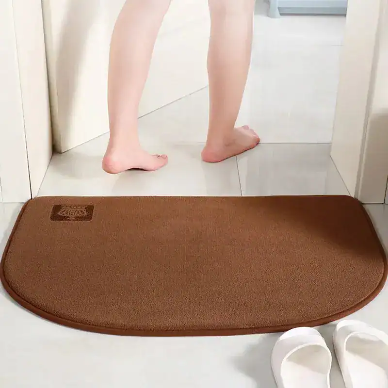 Brauner Badteppich mit weicher Oberfläche und runder Ecke, ideal für Badezimmer.