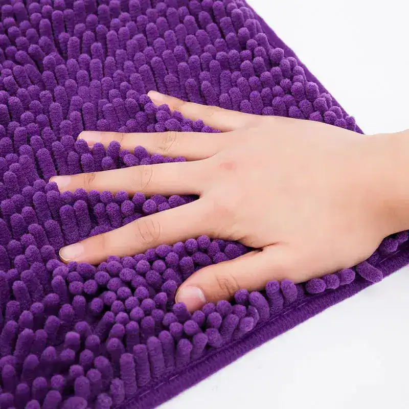 Violetter Chenille-Badteppich 60x90 cm, weicher Touch, Hand darauf.