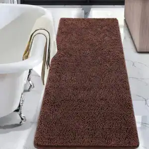 Dunkelbrauner Badteppich mit Chenille-Struktur vor Badewanne.