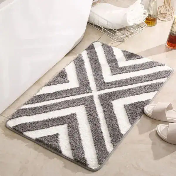 Gestreifter Badteppich mit Chevron-Muster in Grau-Weiß, weicher Faser für Komfort und Stil im Badezimmer.