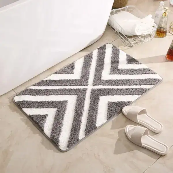 Gestreifter Badteppich mit grau-weißem Chevron-Muster für Komfort und Stil im Badezimmer.