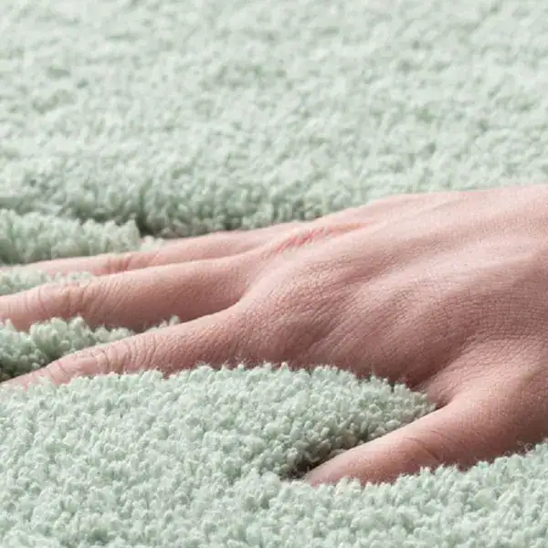 Hochflor Badteppich in sanftem Grün, weicher Touch für optimalen Fußkomfort im Badezimmer.