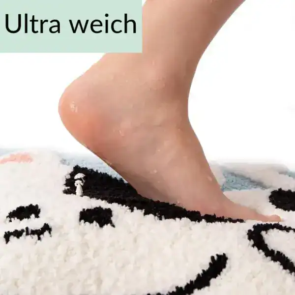 Feuchteter Fuß auf weichem Badteppich mit Katzenmotiv.