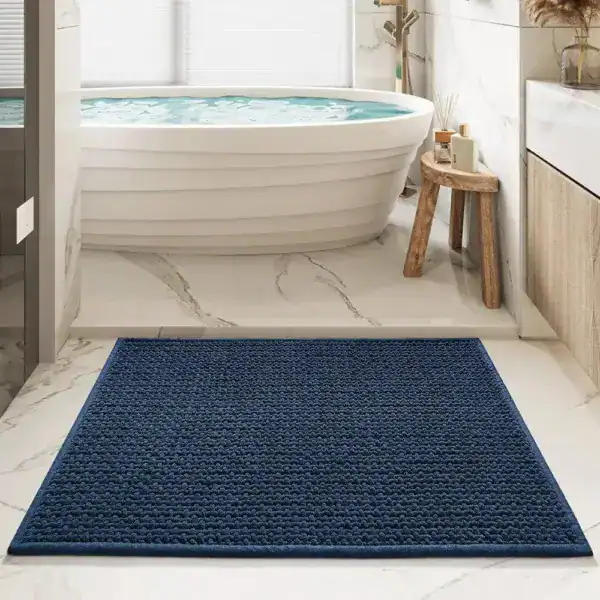 Marineblauer Badteppich mit strukturierter Oberfläche vor einer Badewanne.