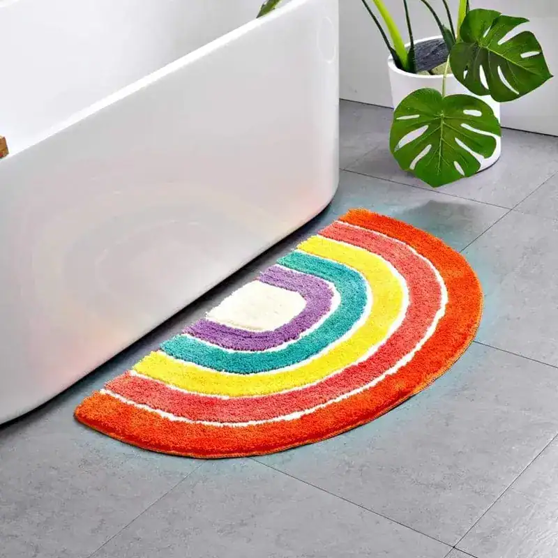 Mehrfarbiger Badezimmer-Teppich in Regenbogenfarben vor Badewanne.