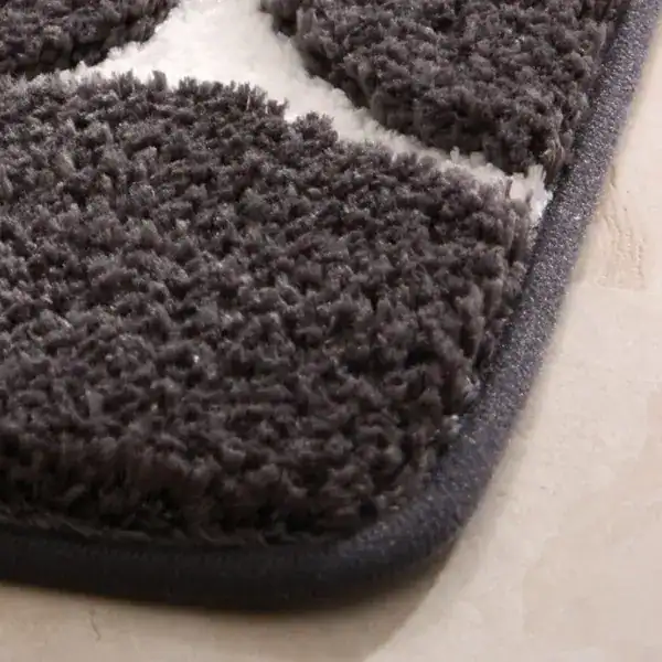 Dunkelgrauer Badteppich Memory Foam mit weicher Textur und weißem Kontraststreifen.